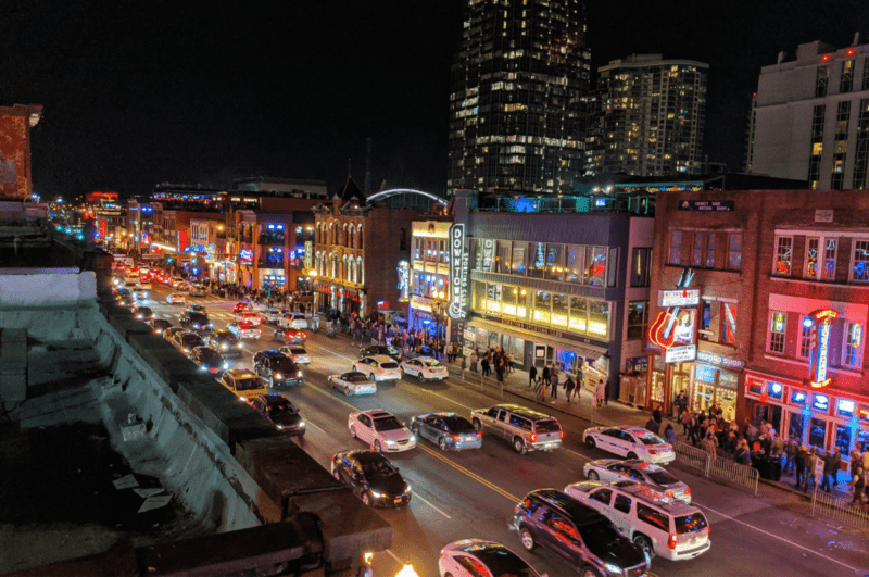 Cars and people on Broadway at night. One of the best things to do in downtown Nashville TN